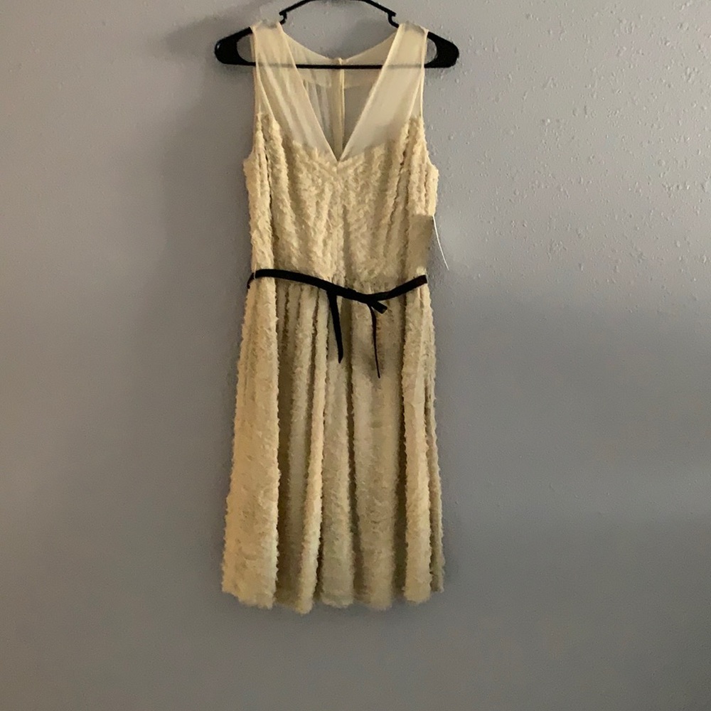 Beige feathered dress with black leather belt